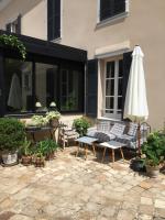 a patio with an umbrella and chairs and a table with an umbrella at Le Jardin Cathedrale in Chartres