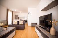 Televízia a/alebo spoločenská miestnosť v ubytovaní Dok Apartment