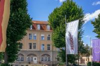 クヴェードリンブルクにあるREGIOHOTEL Quedlinburger Hof Quedlinburgの旗が掲げられた建物