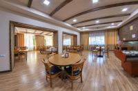 uma sala de jantar com mesas e cadeiras de madeira em Vanadzor Armenia Hotel em Vanadzor