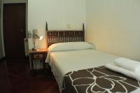 A bed or beds in a room at Hostal Esmeralda