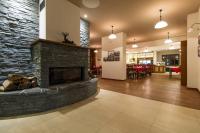 een lobby met een stenen open haard en een restaurant bij REJVÍZ 1 Hotel & Spa in Rejvíz