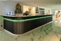 a bar in a restaurant with green lights at 6717 Nature Hôtel &amp; Spa Le Clos des Délices in Ottrott