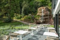a row of tables and chairs on a balcony with a waterfall at 6717 Nature Hôtel &amp; Spa Le Clos des Délices in Ottrott