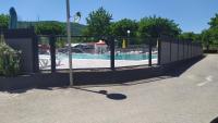 a fence with a pool in the background at mobil-home du lac de Foix in Foix
