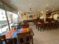 Un comedor con mesas y sillas de madera. en Hotel Cims Pas de La Casa, en Pas de la Casa