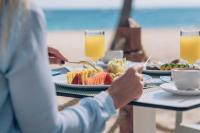 プンタ・カナにあるIberostar Selection Coral Bavaro - All Inclusiveの食べ物の皿を持ってテーブルに座っている人