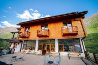 un edificio con sillas y mesas en un patio en Alpenhaus Kazbegi Hotel &amp; Restaurant, en Kazbegi