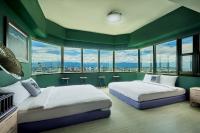 two beds in a room with green walls and windows at 安蘭居旅店 An Lan Jie Hotel in Chiayi City