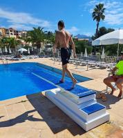 a man standing on a board near a swimming pool at L&#39;écrin du Cap Esterel in Saint-Raphaël