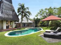 a resort with a swimming pool and an umbrella at Novotel Lombok Resort & Villas in Kuta Lombok