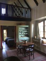 a living room with a table and chairs and a bed at Gîte Maison Maitri in Forgès