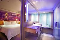 a bedroom with a bed and a sink and a tub at FX INN Kaohsiung Zhonghua Road Branch in Kaohsiung