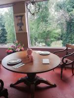 einen Holztisch in einem Zimmer mit einem großen Fenster in der Unterkunft Chambre d'hôte Moulin du Breuil. in Pionnat