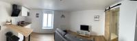 a living room with a couch and a television at Studio Cosy in Concarneau