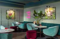 un restaurante con sillas azules, mesas y carteles en Falkensteiner Boutique Hotel Prague, en Praga