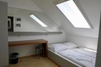 a bedroom with a bed and two skylights at Storchencamp Gästehaus Purbach in Purbach am Neusiedlersee