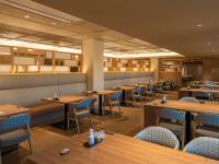 a restaurant with wooden tables and blue chairs at KAMENOI HOTEL Kamogawa in Kamogawa