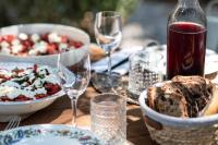 un tavolo in legno con piatti di cibo e bicchieri di vino di Maison Sumiane a Brignoles