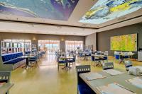 een restaurant met tafels en stoelen en een groot schilderij aan het plafond bij Yasmin Bodrum Resort in Gumusluk