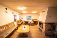 a living room with benches and a fireplace at Apartmány Penzion Koula in Pec pod Sněžkou