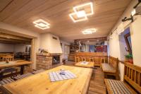 a large room with a wooden table and a kitchen at Apartmány Penzion Koula in Pec pod Sněžkou