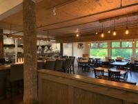 een restaurant met tafels en stoelen en een bar bij Woodbridge Inn & Tavern in Jasper