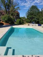 a swimming pool with blue water in a yard at Les Pierres Lotoises - gîte les grandes pierres in Reilhaguet