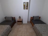 a room with two beds and a table with a lamp at Adorable 2 floors two bedroom vacation maisonette in Nea Potidaea