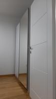 an empty room with white doors and a wooden floor at Apartman 222 in Brčko