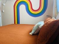 a bedroom with a bed with a rainbow on the wall at Lower Price, More Style, Discount Studio In San Juan,Pr, Beach, Free Bikes in San Juan