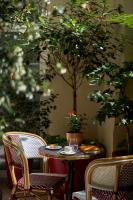 a table with two chairs and a table with a tree at Hotel Villa Romantic &amp; Spa in Paris