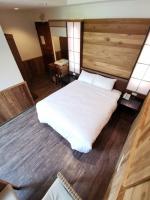 a bedroom with a white bed and a wooden floor at Dreamtown in Ren&#39;ai