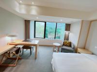 a hotel room with a bed and a desk and a table at Sonnien Hotel in Taipei