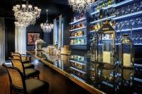 Un bar con paredes azules y lámparas de araña. en Belfry & Spa by Ligne St Barth, en Lourdes