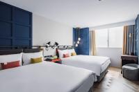 two beds in a hotel room with blue walls at OLAH Poshtel - Taichung Station in Taichung