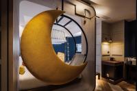 a large yellow crescent shaped mirror in a hotel room at OLAH Poshtel - Taichung Station in Taichung