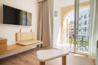 a living room with a tv and a chair and a window at Hotel & Spa Blau Parc in San Antonio