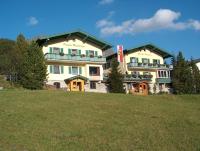 a large building on top of a green field at Pension Weinberger in Obertauern
