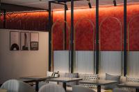 a restaurant with tables and chairs and red dividers at OLAH Poshtel - Taichung Station in Taichung