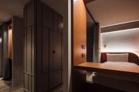 a small bedroom with a bed and a mirror at OLAH Poshtel - Taichung Station in Taichung