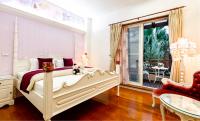 a bedroom with a white bed and a balcony at Spring Villa in Dongshan