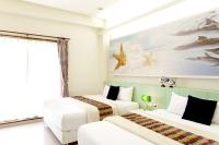 a bedroom with two beds and a painting of fishes at Spring Villa in Dongshan