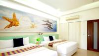 a bedroom with two beds and a painting of a beach at Spring Villa in Dongshan