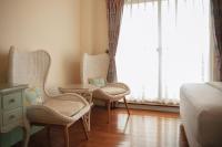 a bedroom with two chairs and a table and a bed at Spring Villa in Dongshan