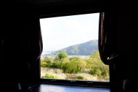 a window with a view of a field and mountains at Guesthouse Sakuya in Fujikawaguchiko