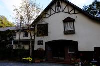 a white house with a window and a tree at Guesthouse Sakuya in Fujikawaguchiko