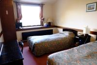 a hotel room with two beds and a window at Guesthouse Sakuya in Fujikawaguchiko