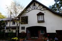 a white house with a black roof and a window at Guesthouse Sakuya in Fujikawaguchiko