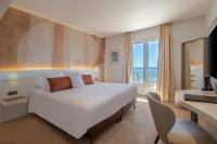 a bedroom with a large bed with a view of the ocean at Best Western Premier Hotel Prince de Galles in Menton